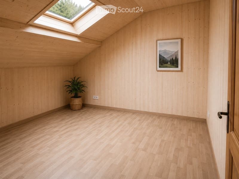 Empty room with light wooden walls and floor, skylight windows, a potted plant, and a framed picture on the wall.