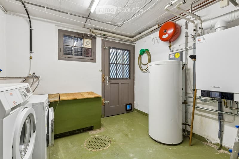 Utility room with a washing machine, water heater, wooden bench, door, window, fire extinguisher, and a hanger.