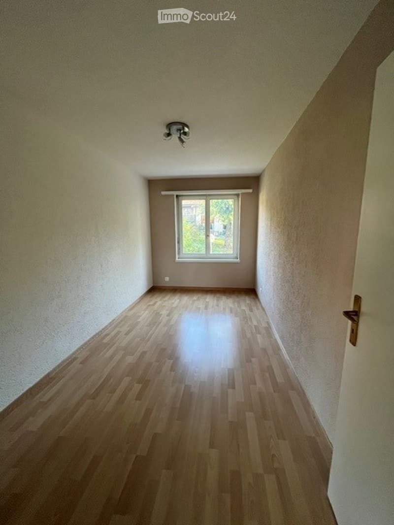 Empty room with wooden flooring, white walls, and a single window with blinds. No furniture or equipment present.