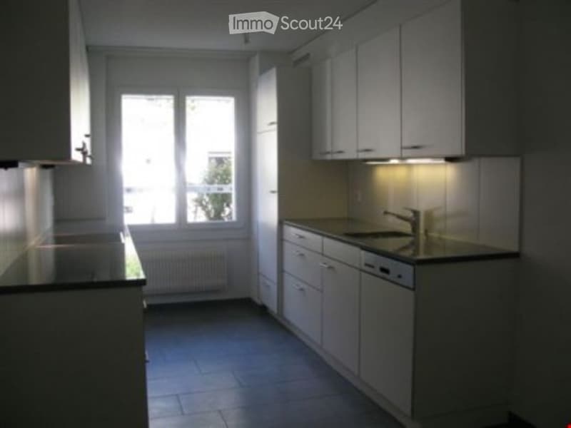 white cabinets, black countertops, dishwasher, modern lighting