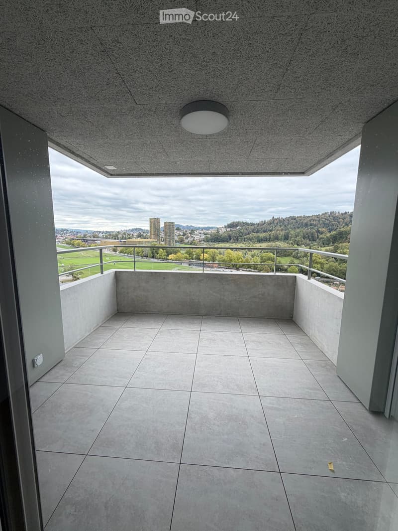 Modern balcony with tiled floor, metal railing, and expansive city view.