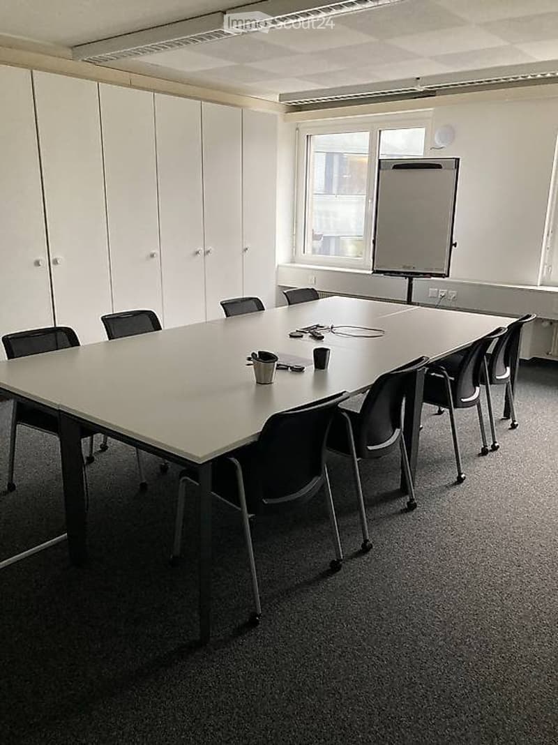 empty room, large table, chairs, white cabinets, whiteboard, windows, outlet