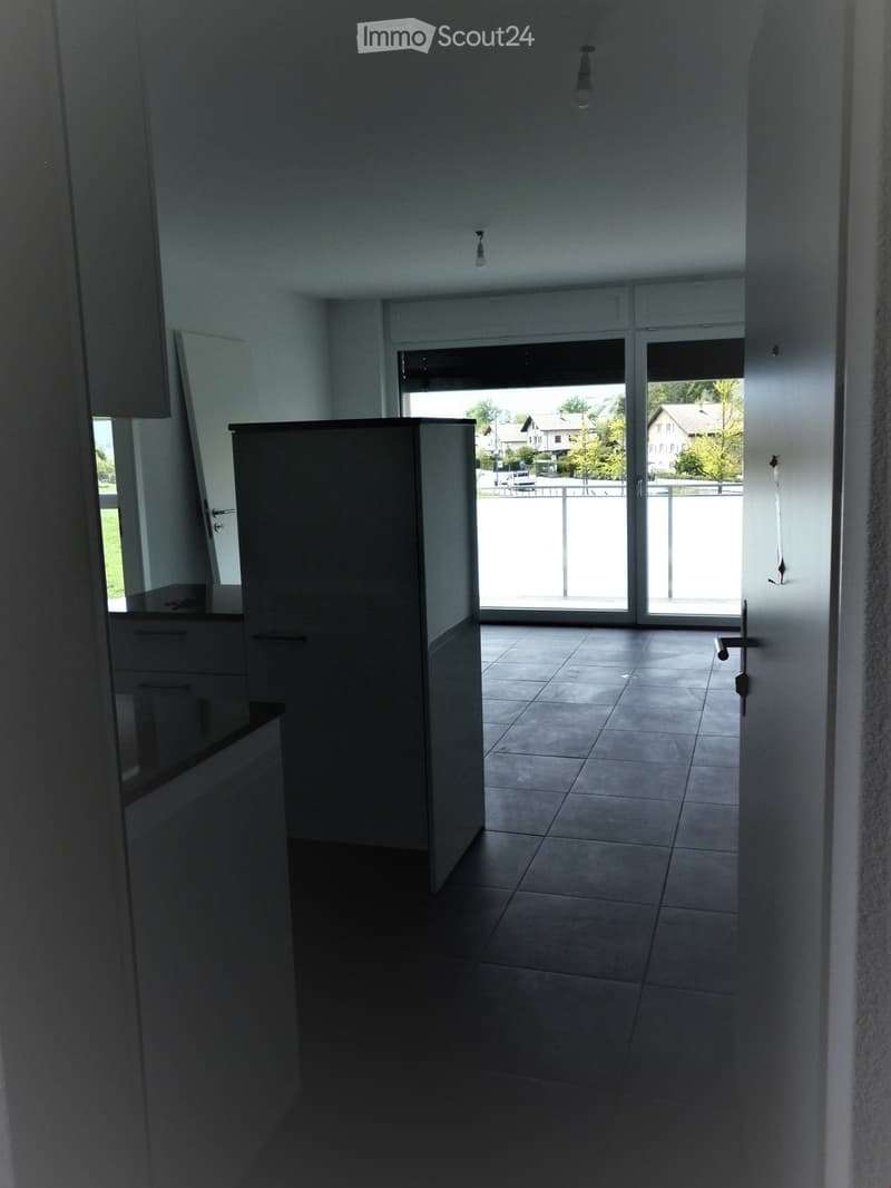 Empty room with tiled floor, white walls, and large sliding glass doors leading to a balcony area.