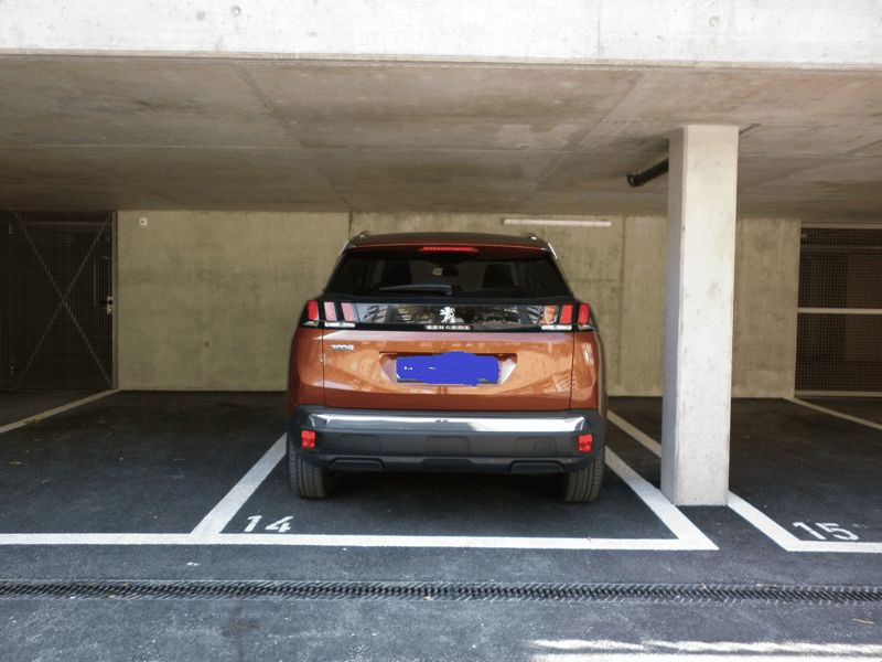 Underground parking area with a single car parked in a designated spot, marked with the number 144.