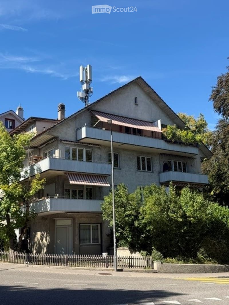 Multi-story residential building with balconies, large windows, and a modern design.