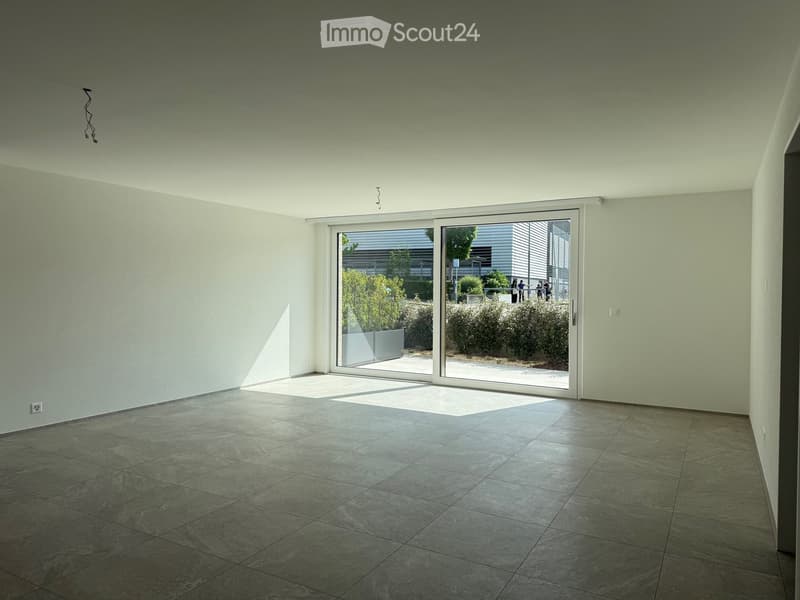 Empty room with tiled floor, large sliding glass door leading to outdoor area, light-colored walls, and visible electrical outlets.