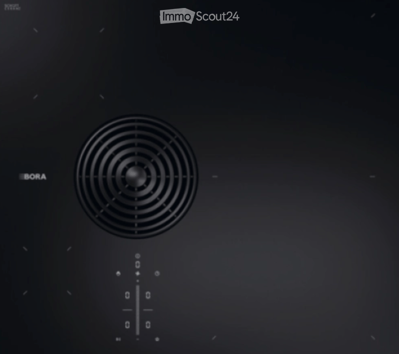 Modern induction cooktop with a sleek, black surface and a central circular cooking zone.