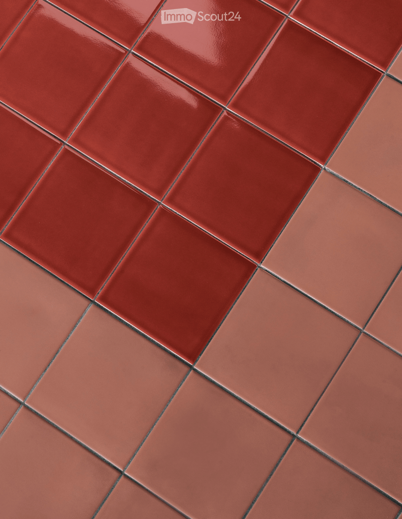 Close-up of red tiles with a glossy finish, arranged in a diagonal pattern, showing clean and uniform appearance.