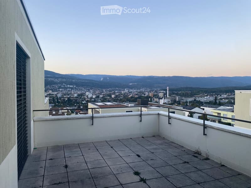 Roof terrace with tiled floor, white walls, metal railing, and a panoramic cityscape view.