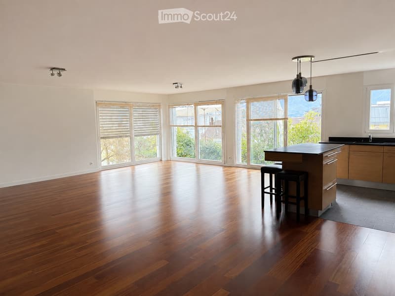 Open, unfurnished room with wooden flooring, large windows, and modern lighting fixtures.