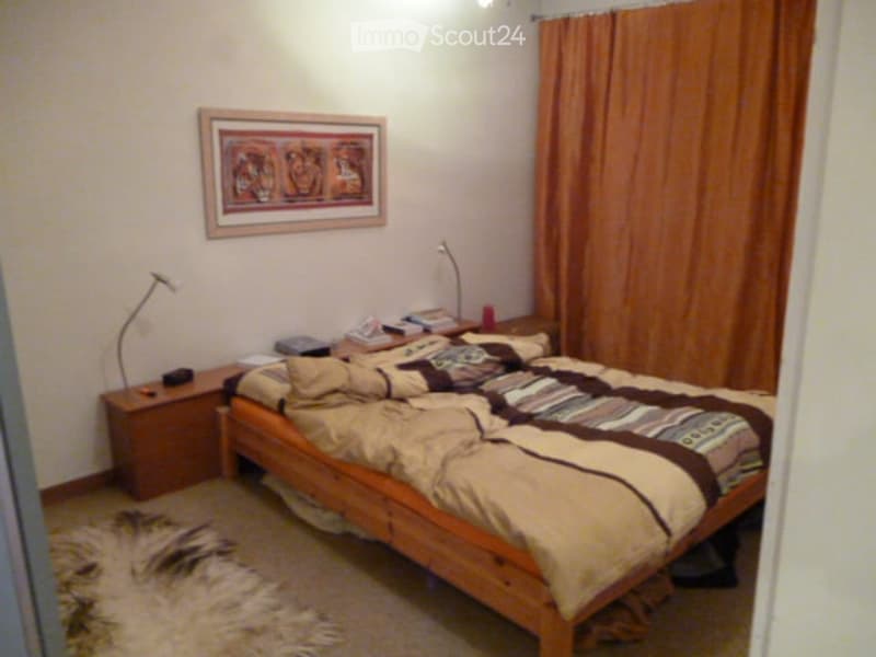 Bedroom with a bed, nightstands with lamps, rug, curtains, and a framed picture on the wall