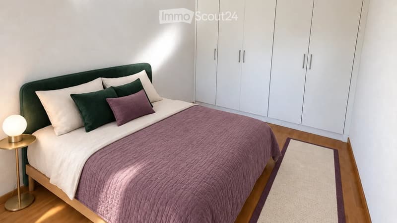 Modern bedroom with a neatly made bed, white wardrobe, nightstand with a lamp, and a small rug on the floor.