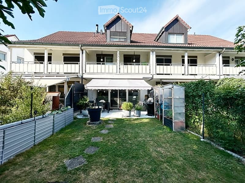 Courtyard with a covered seating area, potted plants, and multiple balconies overlooking the space.