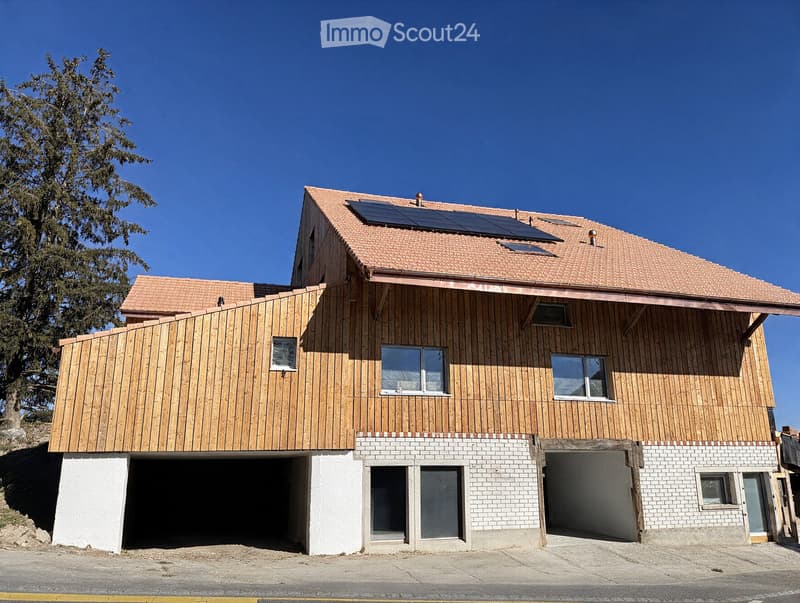 Modern two-story house with wooden siding, red-tiled roof, solar panels, and two garage entrances.