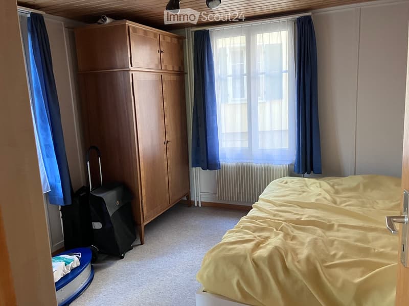 Bedroom with a single bed, wardrobe, suitcase, and luggage near the window.