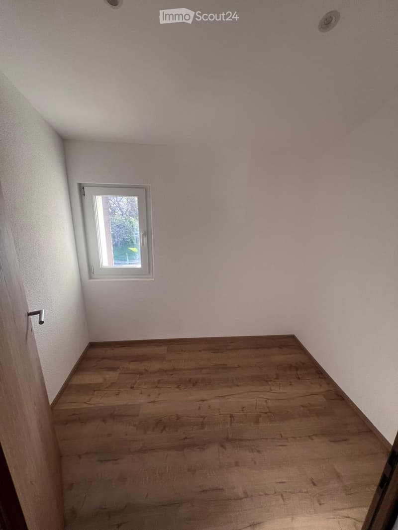 Small room with white walls, hardwood flooring, and a single window overlooking the outdoors.