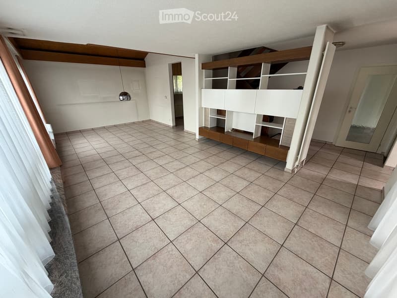 Empty room with tiled floor, white walls, and a white shelving unit with wooden base. No furniture or personal items present.