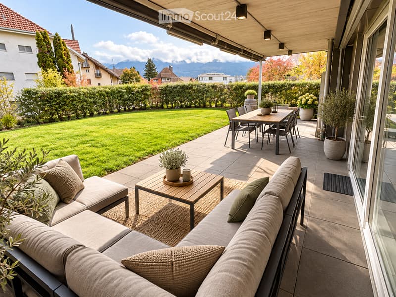 A modern, covered balcony with a comfortable sofa, coffee table, dining area, and potted plants, overlooking a well-maintained garden and scenic mountain view.