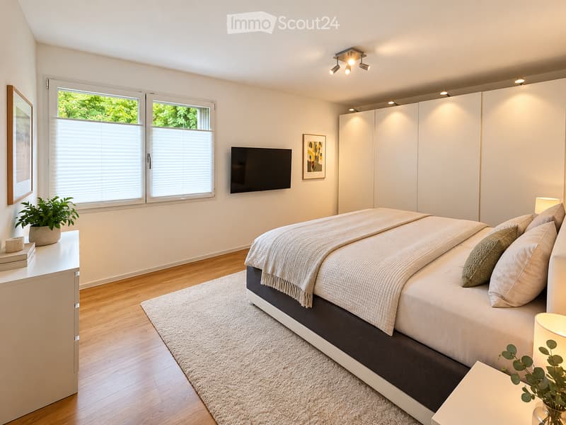 Modern bedroom with a large bed, nightstands, lamps, a television, and a wardrobe. The room features wooden flooring, large windows with blinds, and decorative plants.