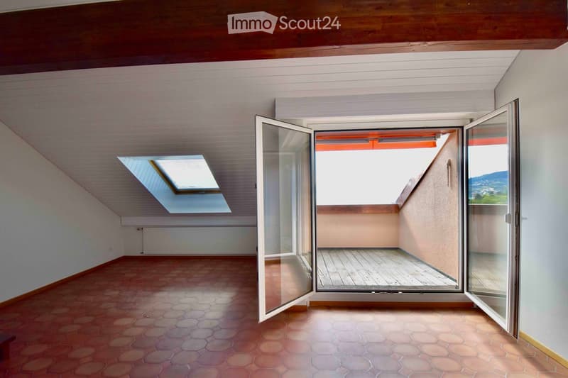 Empty room with hexagonal tiled floor, white walls, wooden ceiling, large glass doors leading to a balcony, and a skylight above.