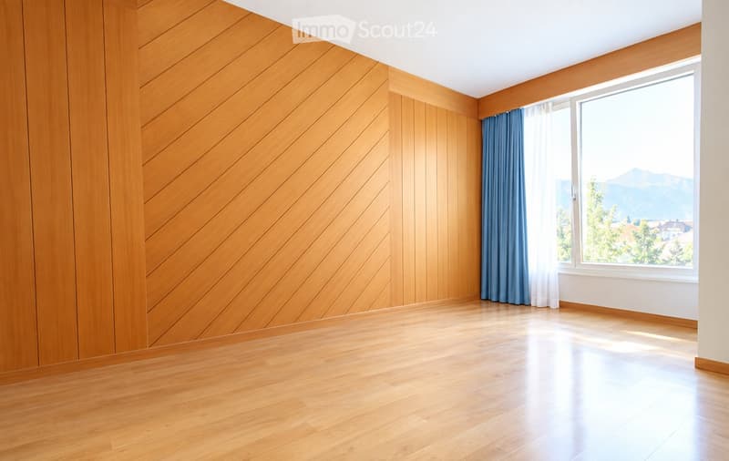Empty room with wooden walls and floor, large window with blue curtains, and a scenic mountain view.