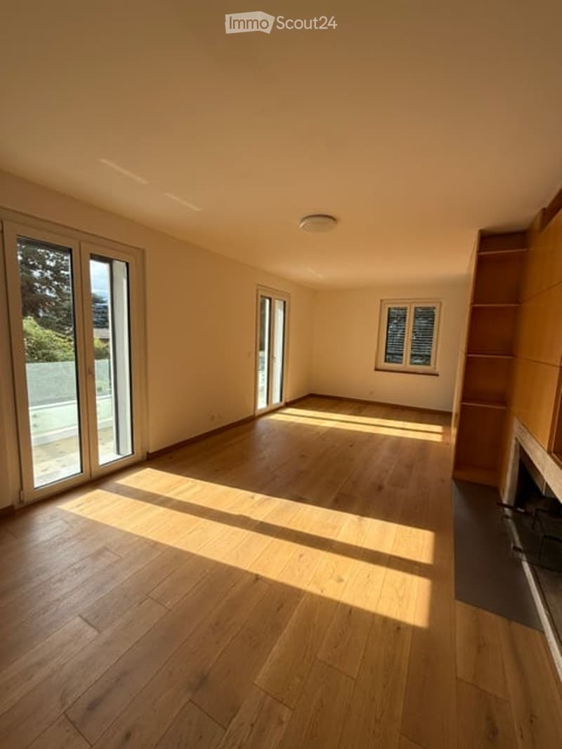 Empty room with wooden flooring, large windows, and natural light. No furniture or equipment present.
