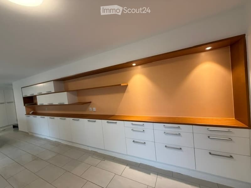 Modern kitchen with white cabinets, wooden countertops, and built-in shelves. Clean and minimalist design with a warm, neutral color palette.