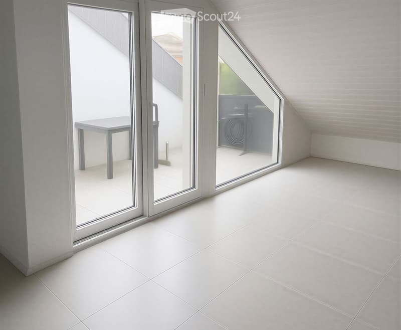 Modern balcony with white tiled floor, large glass sliding doors, and a small grey table visible inside the room.
