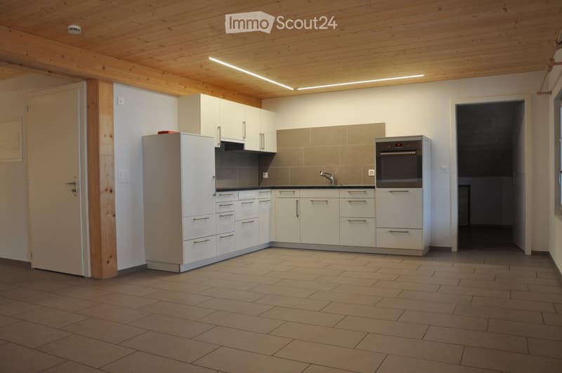 Modern kitchen with white cabinets, a refrigerator, an oven, and a tiled floor. The space features a sleek design with a wooden ceiling and built-in storage.