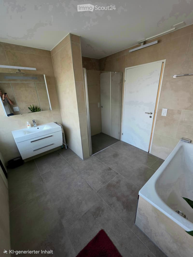 Modern bathroom with a white sink, bathtub, large mirror, and a glass-enclosed shower area. The floor is tiled, and the walls are covered in beige tiles.
