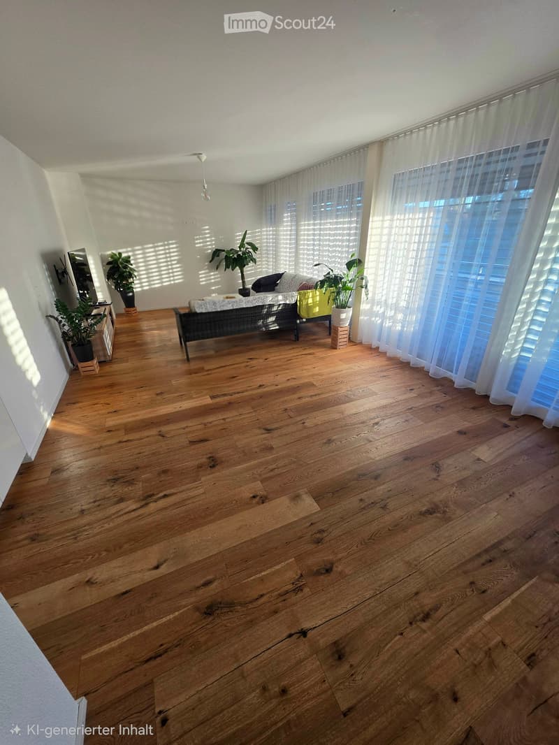 Bright living room with wooden flooring, large windows with sheer curtains, a sofa, potted plants, and a mirror on the wall.