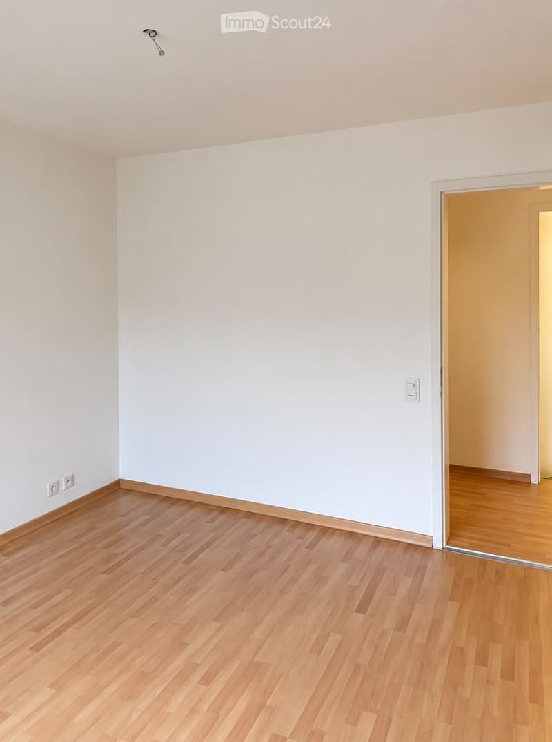 Empty room with light wooden flooring and white walls. No furniture or equipment present.