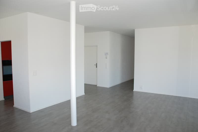 Empty room with white walls, grey tiled floor, and a red cabinet with a built-in oven. No furniture or personal items present.