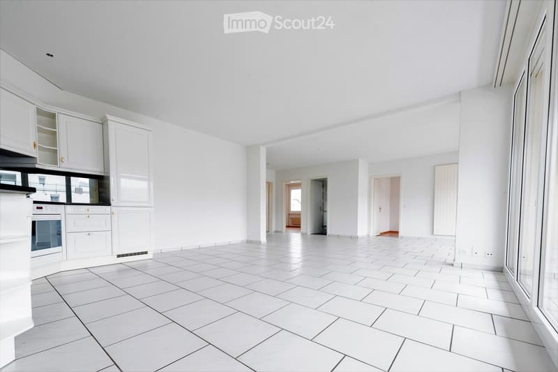 Empty room with white tiled floor, white walls, and white cabinetry. No furniture or equipment visible.