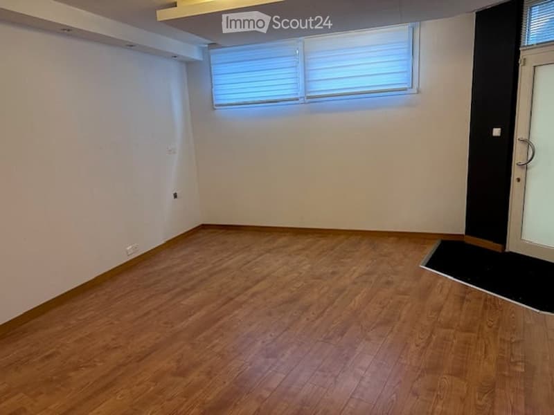 Empty room with wooden flooring, white walls, and a window with blinds. No furniture or equipment present.