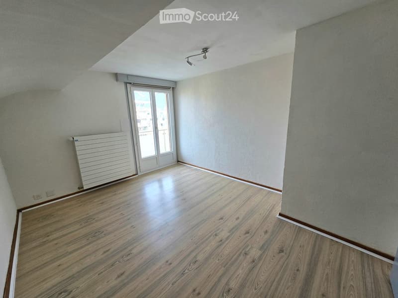 Empty room with wooden flooring, white walls, and a door leading to a balcony or outdoor area.