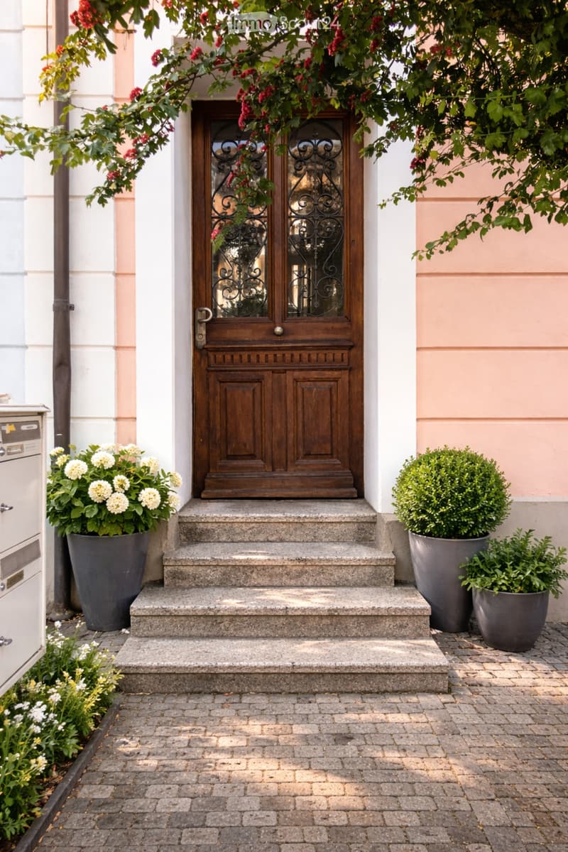 Entrance to a house with a wooden double door, stone steps, and potted plants on either side.