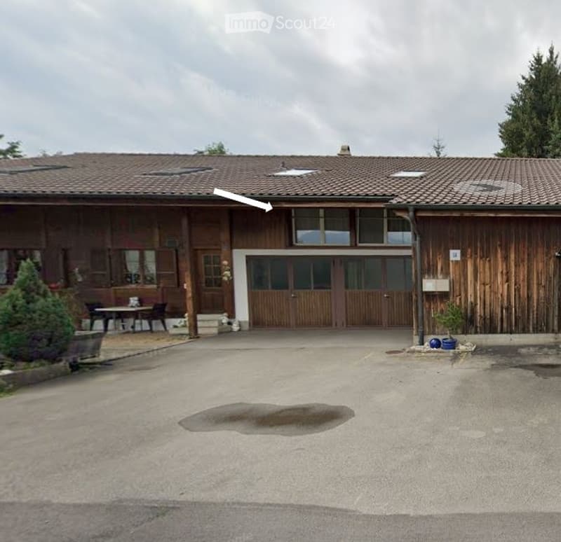 wooden building, brown roof, large windows, parking lot in front