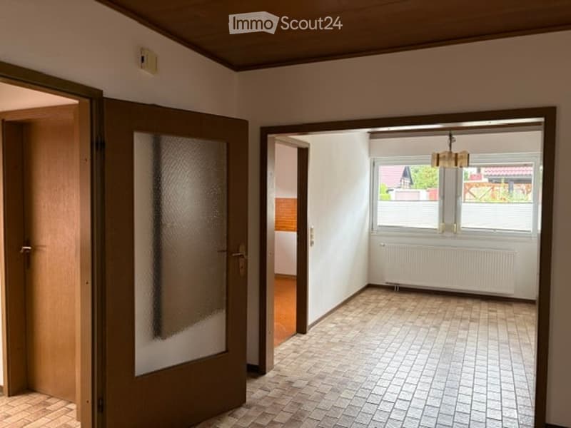 Empty room with tiled floor, white walls, and large windows. No furniture or equipment present.