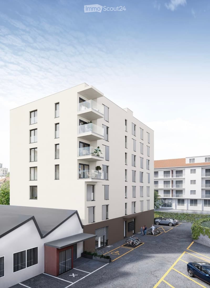 Modern multi-story residential building with balconies, parking area, and bicycles.