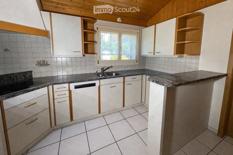 Modern kitchen with white cabinets, granite countertops, a sink, and a dishwasher. The space features a window with a view and a tiled backsplash.