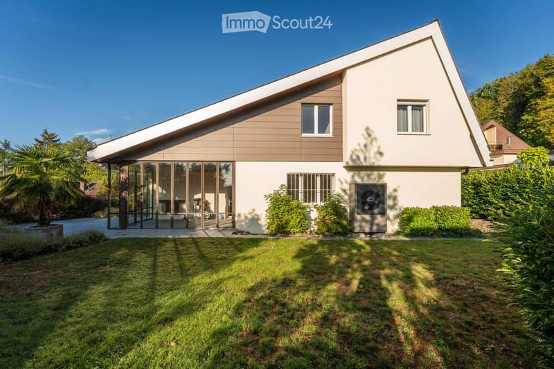 Modern two-story house with a combination of white and brown exterior walls, large glass sliding doors, and a well-maintained lawn.