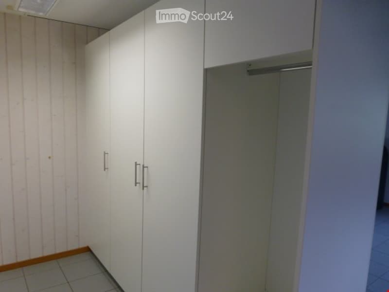 Empty room with white built-in wardrobes and a tiled floor. No furniture or equipment present.