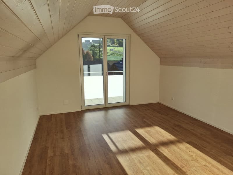 Empty room with wooden flooring, white walls, and a large sliding glass door leading to an outdoor area.