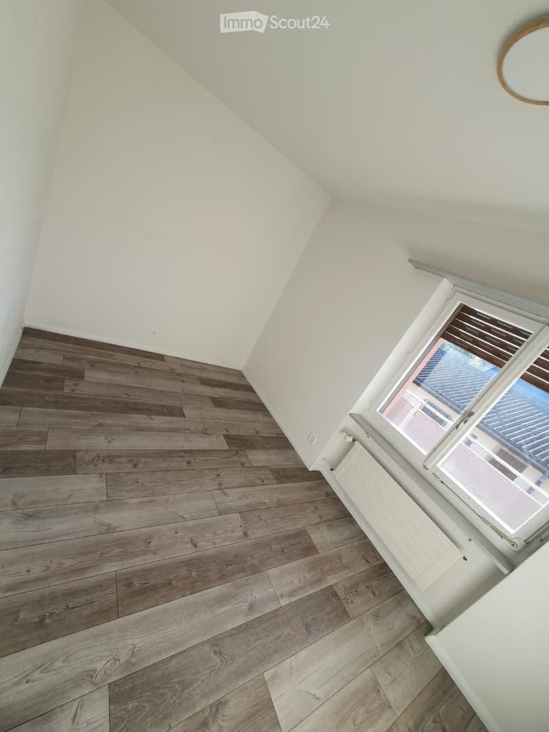 Empty room with wooden flooring, white walls, and a window with blinds. No furniture or equipment is present.