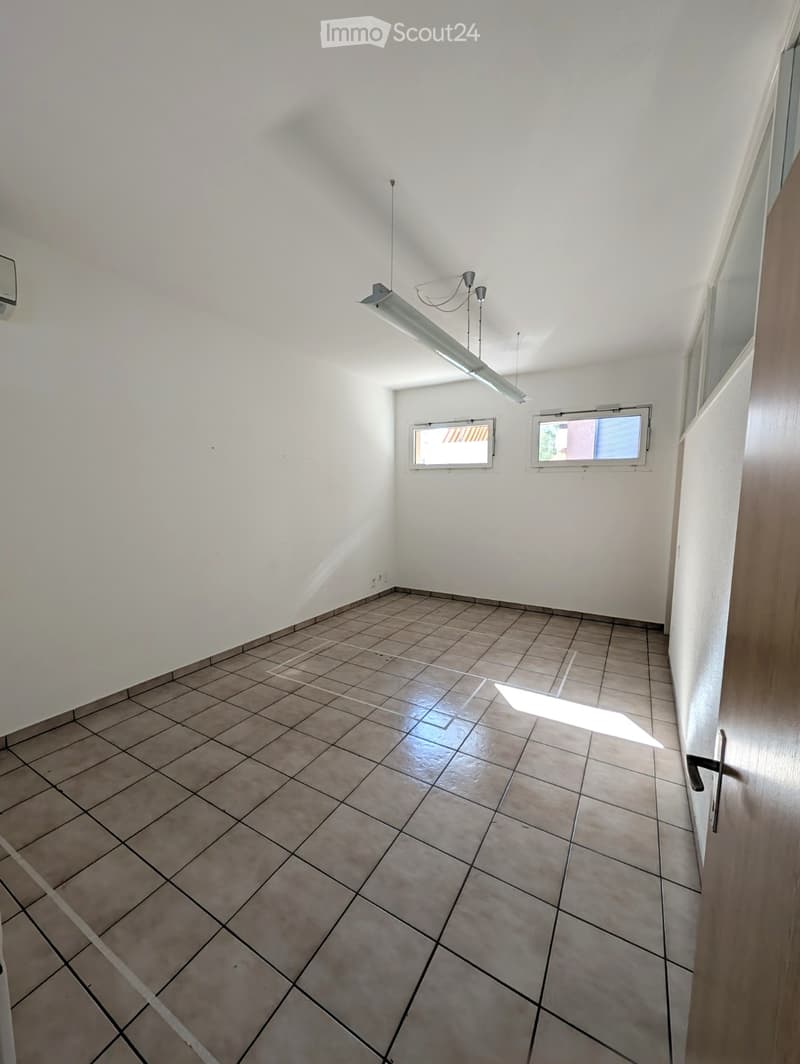 Empty room with tiled floor, white walls, and two windows. No furniture or equipment present.