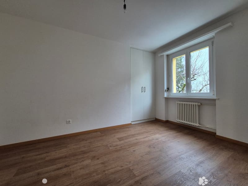 empty room, wooden floor, white walls, large window, white wardrobe, white radiator