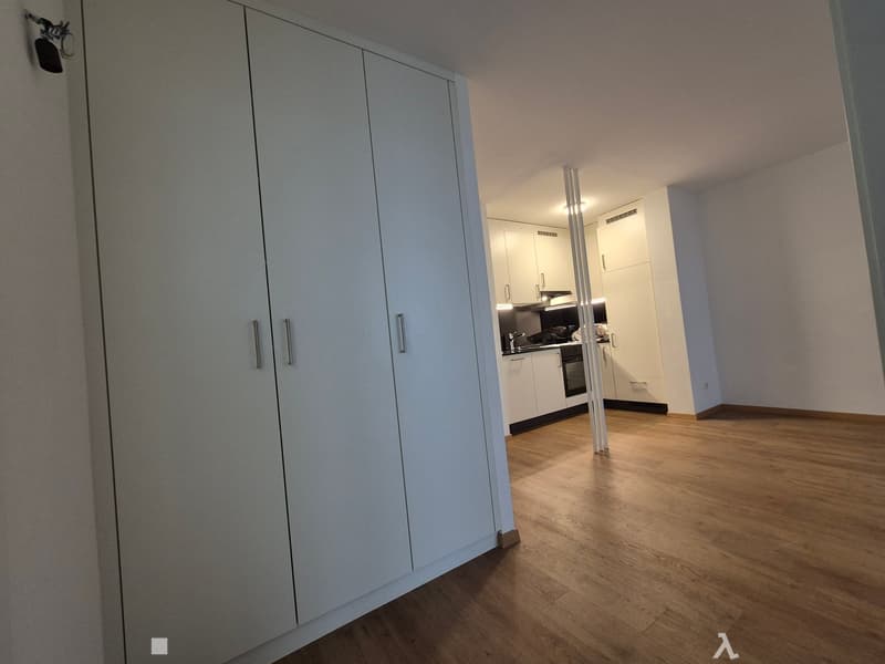 white wooden cabinets, white walls, white wooden floor, open kitchen with stove and sink