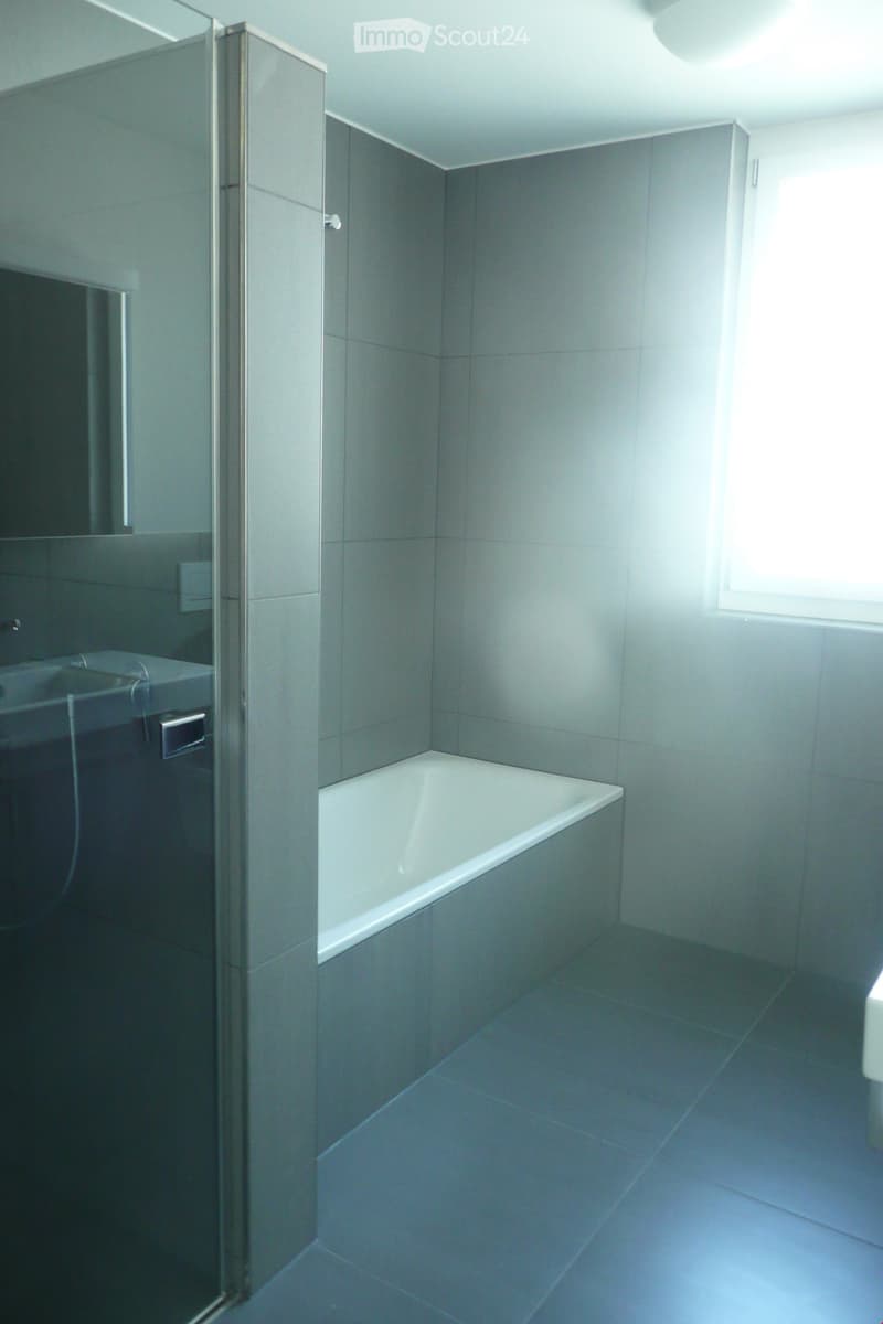 Bathroom with bathtub, sink, mirror, and window