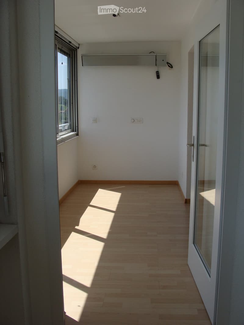 empty room, white walls, wooden floor, white doors, window with white frame, power outlets, small balcony, natural light